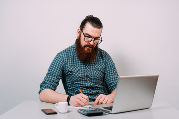 Bearded man writing at the desk