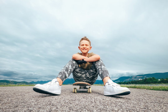 Boy sits on skate board