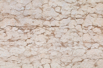 rissige Natursteinmauer hellrosa mit Fissuren