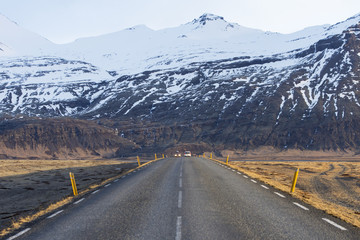 Icelandic road with volcanic snow covered mountains in wintertime, Iceland