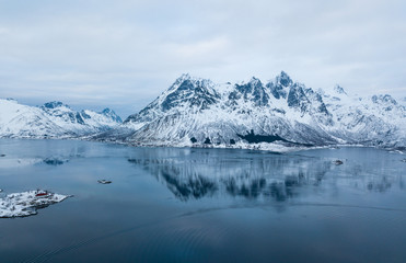 Aerial winter view of Lofoten Islands, Nordland, Norway, with fjord, road and mountains, shot from drone