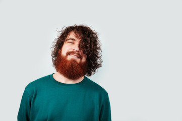 Portrait of handsome man with long red beard and long hair looking at camera over white background