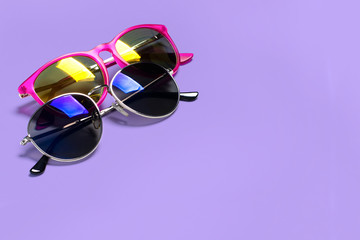 Too stylish fashionable sunglasses isolated on a purple background. The concept of sun, summer, holidays, vacations, travel