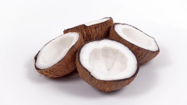 Four ripe tropical coconut halves with yummy white pulp rotating on white isolated background. Healthy fresh tropical fruits. Loopable seamless cocos rotating