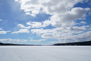 Large blue sky with white clouds on the lake at spring time during a beautiful day.