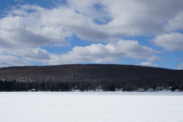 Large blue sky with white clouds on the lake at spring time during a beautiful day.
