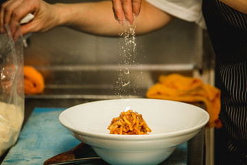 Kitchen moment of serving homemade pasta to a guest