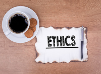 ethics. Wooden desk with stationery and a cup of coffee.