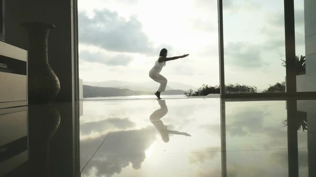 Sport woman practicing chair pose Utkatasana and eagle pose Garudasana