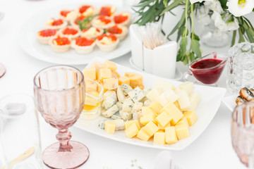 Cheese platter. Plate with food on the table, snacks at the banquet, wedding banquet, table setting, dinner food, gala dinner.