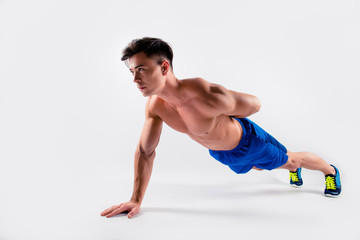 Obraz premium Side profile view photo of strong determined handsome purposeful muscular with perfect body man wearing blue shorts and shoes, isolated on white background, copy-space