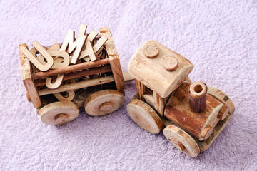 Wooden alphabet letters with toy. Educational concept on purple background