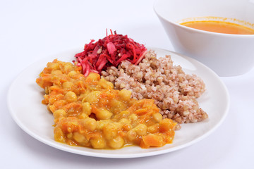 Stewed carrots with chickpeas and buckwheat on a white