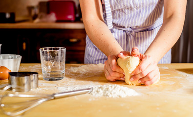 Obraz na płótnie Canvas Woman's hands knead dough on a table