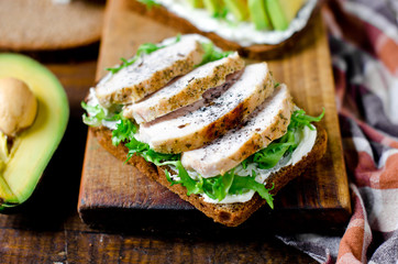 Various healthy toasted sandwiches: avocados, tomatoes, lettuce, chicken breast and curd cheese. healthy snacks