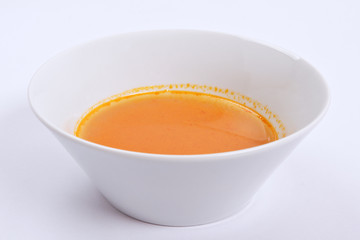 Pumpkin soup with tomatoes on a white