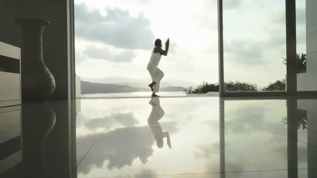 Woman in eagle pose Garudasana and inverted triangle pose Parivrtta Trikonasana