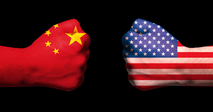 Flags of USA and China on two clenched fists facing each other on black background/usa china trade war concept