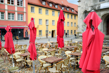 Empty outdoor cafe on beautiful rainy autumn day in Lindau, Germany. Empty chiars and tables under...