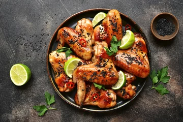 Fototapeten Grilled teriyaki chicken wings with black sesame and lime.Top view. © lilechka75