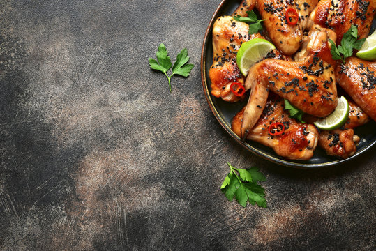 Grilled teriyaki chicken wings with black sesame and lime.Top view with copy space.