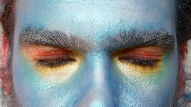 Close-up of male eyes in makeup. The actor portrays fear or suspicion