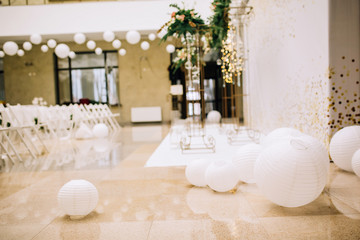 close-up of paper white balls on the background of a decorated hall with chairs and a wedding arch