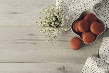 Tasty macarons in a stylish bowl on white marble background. Minimalist concept of style and french chic and selective focus.