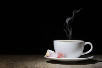 steamed coffee cup on wooden table at the dark