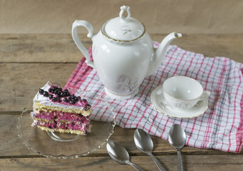 piece of cake on wooden table with cup of tea 