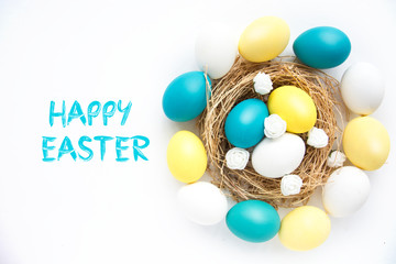 colored blue and yellow Easter eggs in nest on wooden background, selective focus image. Happy Easter card 