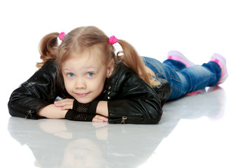 Naklejka premium Little girl lies on the floor