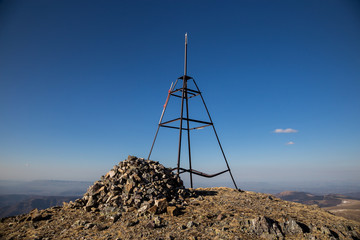 Geodesic sign, bench mark on mountain peak in Caucasus 
