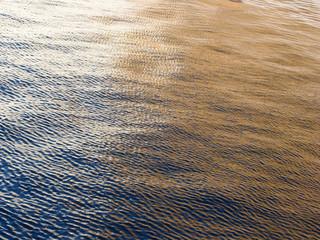 Sunset sea water surface with ripples from the bird's eye view