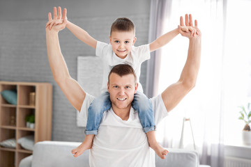 Happy dad playing with his son at home. Father's day celebration