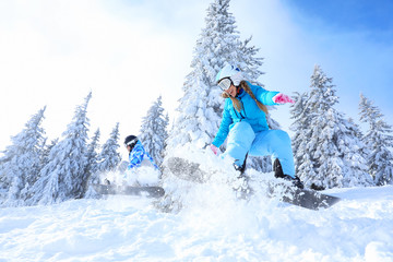Snowboarders on ski piste at snowy resort. Winter vacation