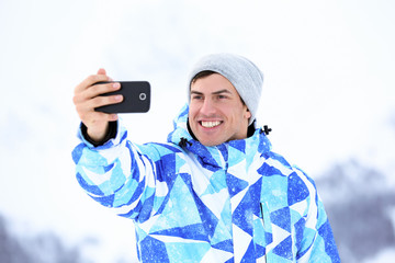 Happy man taking selfie outdoors. Winter vacation