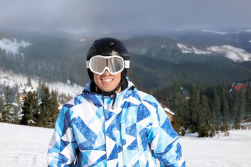 Portrait of happy man at snowy ski resort. Winter vacation