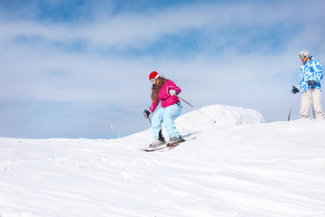 Naklejka na ściany i meble Woman skiing downhill at snowy resort. Winter vacation