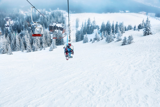 Couple on ski lift at mountain resort. Winter vacation