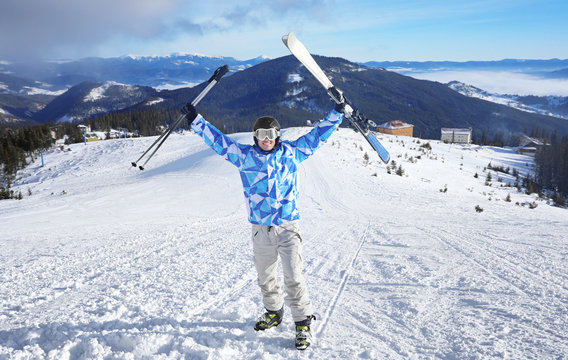 Happy man on ski piste at snowy resort. Winter vacation