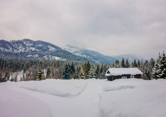 View of traditional mountain wooden houses covered with snow in stunning nature background in Norway