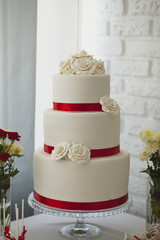 wedding cake with red ribbons