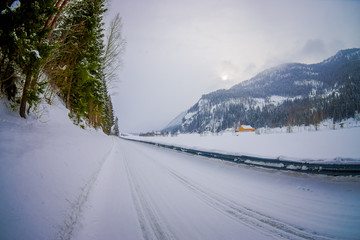 Fototapeta na wymiar Outdoor view of winter road covered with heavy snow and ice in the forest of Norway