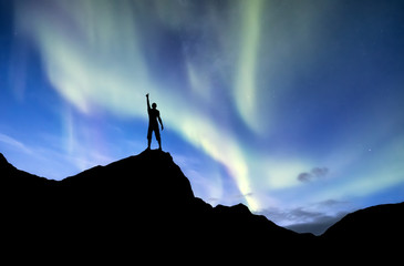 Silhouette of a winner on the northen light backgroun. Concept and idea of active life