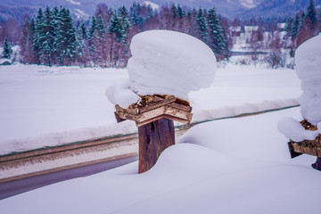 View of winter road snow and ice with some wooden boxes, covered with snow at one side of the road...