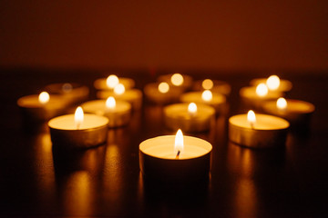 Kemerovo, Russia, fire in the mall, burning candles. Shallow depth of field. Many candles burning at night. Candles background. Many candle flames glowing on dark background. Close-up. Free space.