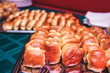 Beautifully decorated catering banquet table with different hamburgers burgers sandwiches on a plate on corporate christmas birthday party event or wedding celebration