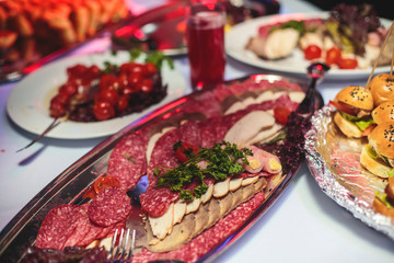 Beautifully decorated catering banquet table with different hamburgers burgers sandwiches on a plate on corporate christmas birthday party event or wedding celebration