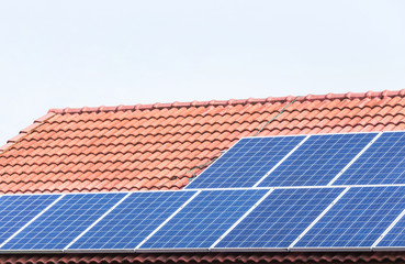 rows array of polycrystalline silicon solar cells or photovoltaics installing on red concrete tiles...